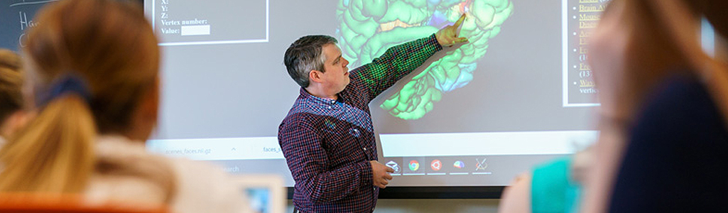 Neuroscience Instructor at front of classroom during a workshop.