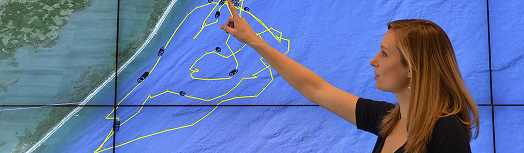 Oceanography Young woman points to a map of ocean currents.
