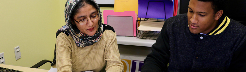 TESL graduate student works with a woman on her skills.