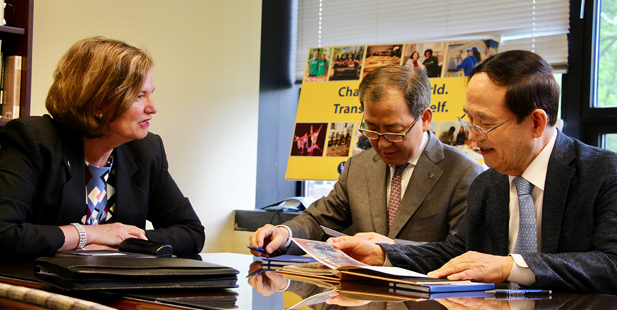 A delegation sits at a table with Director of the School of Urban Affairs and Public Policy, Maria Aristigueta. 