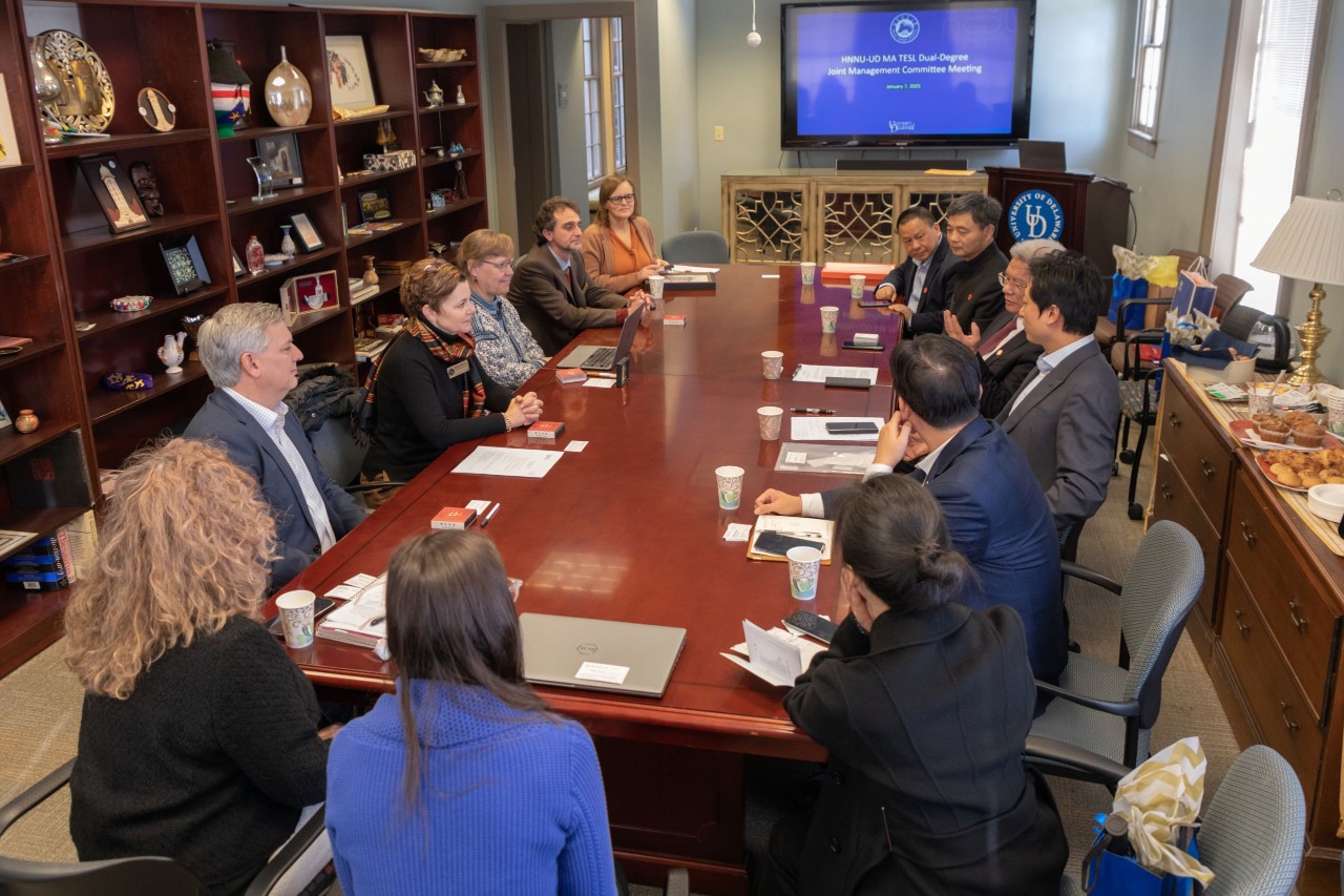 A visiting delegation sits around a conference table with staff from the Center for Global Programs and Services