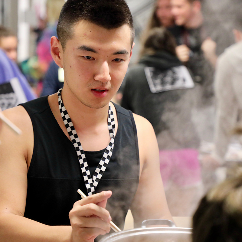 A student stirs their hot pot at an iHouse event