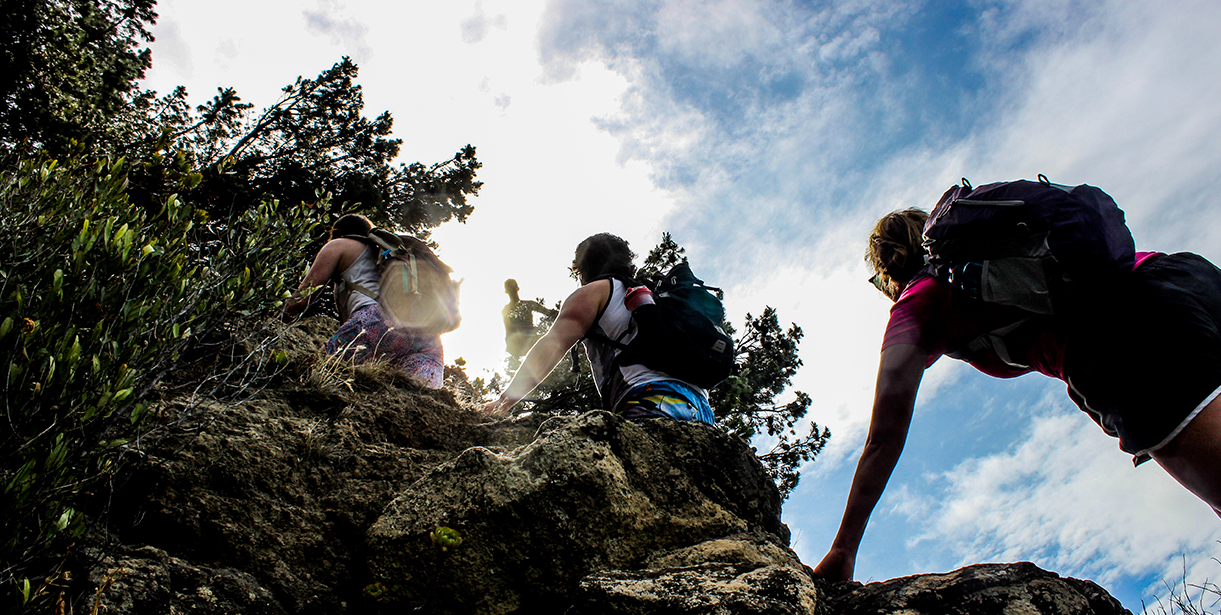 A group of UD students trek up a hill or mountain.