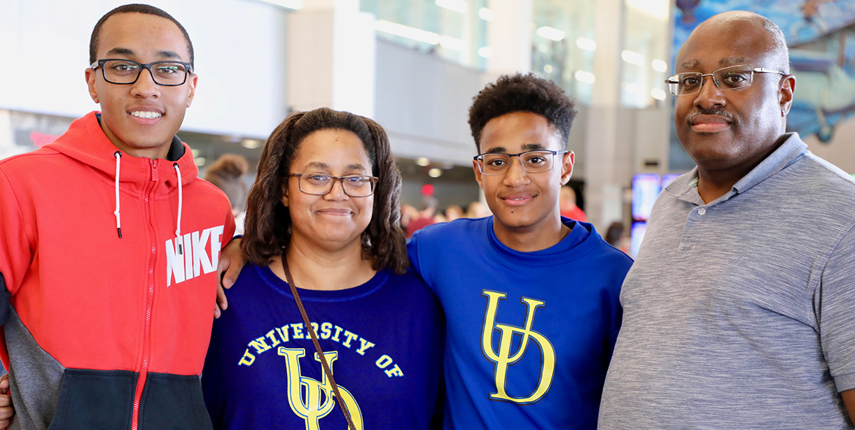 A UD World Scholar family smiles for a photo at the airport