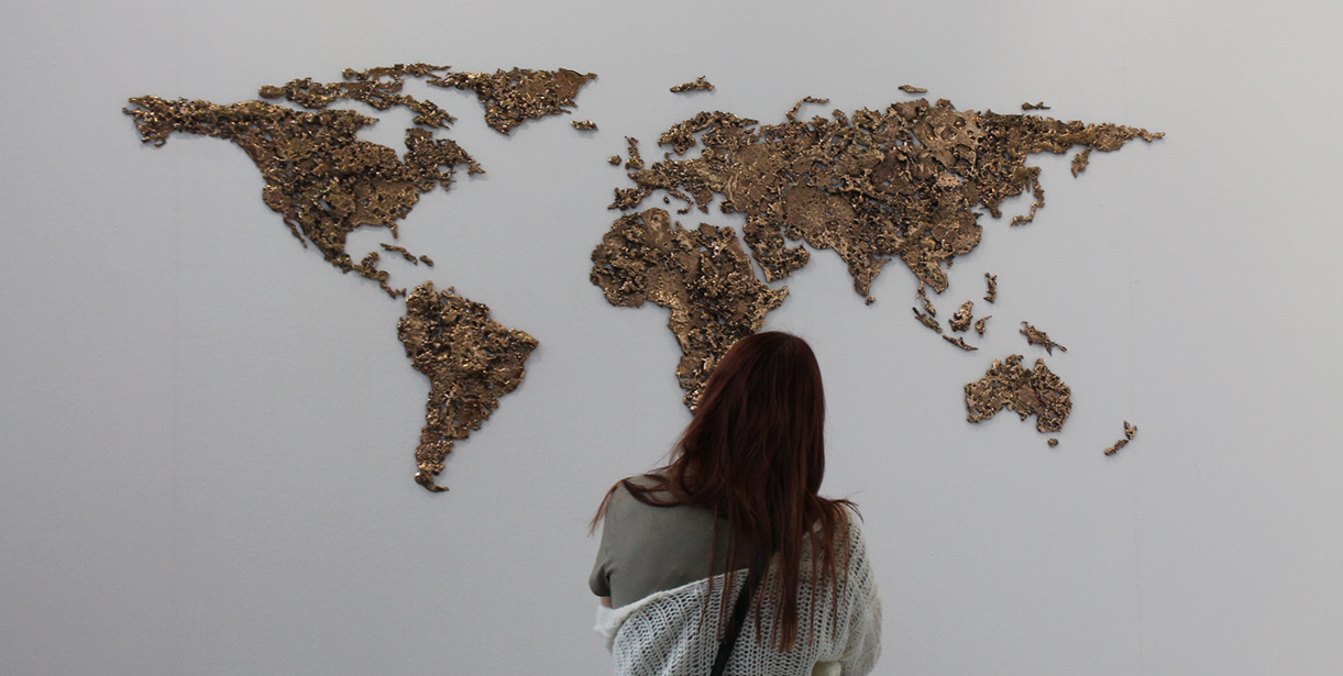 A student stands looking at a world map