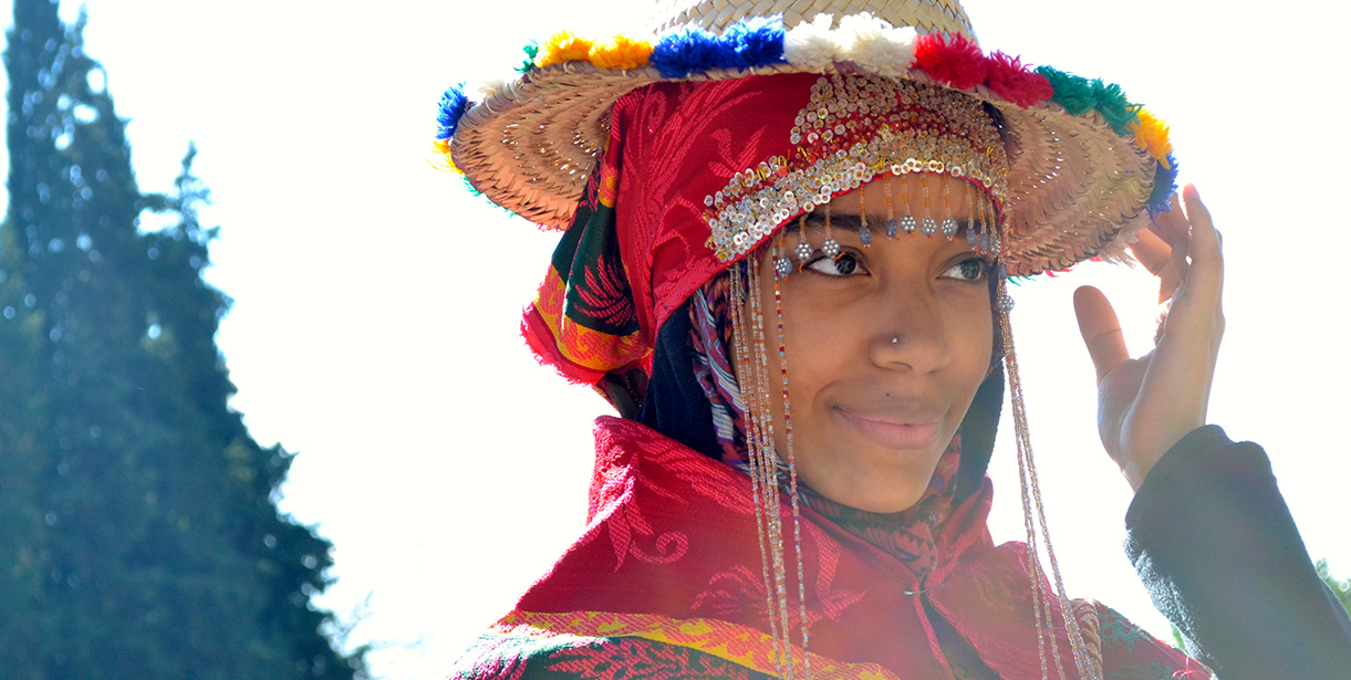 A photo of a student smiling and holding her hat in Morocco. 