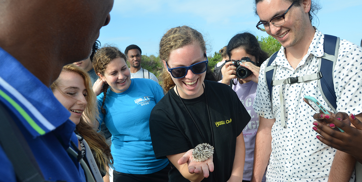 UD students stand around a fellow classmate holding a sea urchin in Martinique.