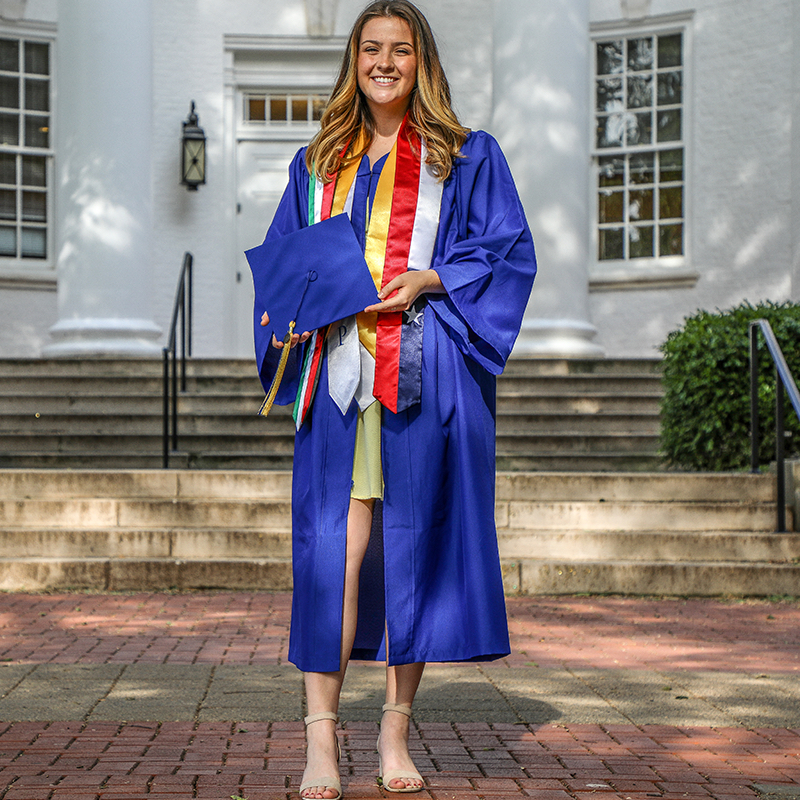 Emily Doris stands on the Green in her Grad Regalia.