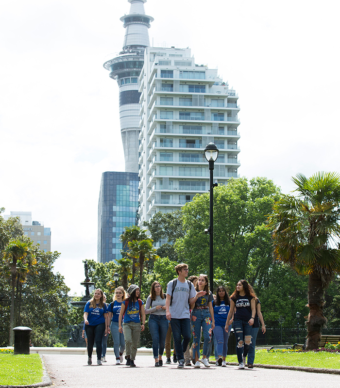 World Scholars walk through campus, surrounded by buildings and greenery.