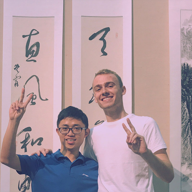 Matthew Anderson and a friend give a peace sign in China