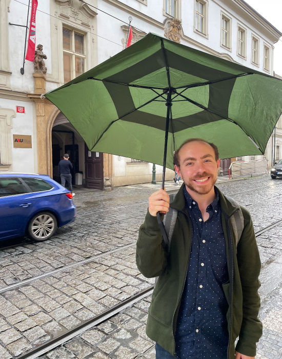 man holding umbrella in city street