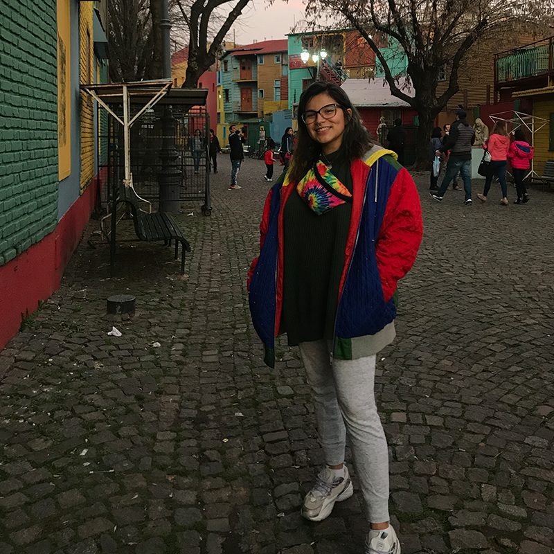 Karelin Torres poses for a photo in front of the buildings of buildings of Caminito in La Boca