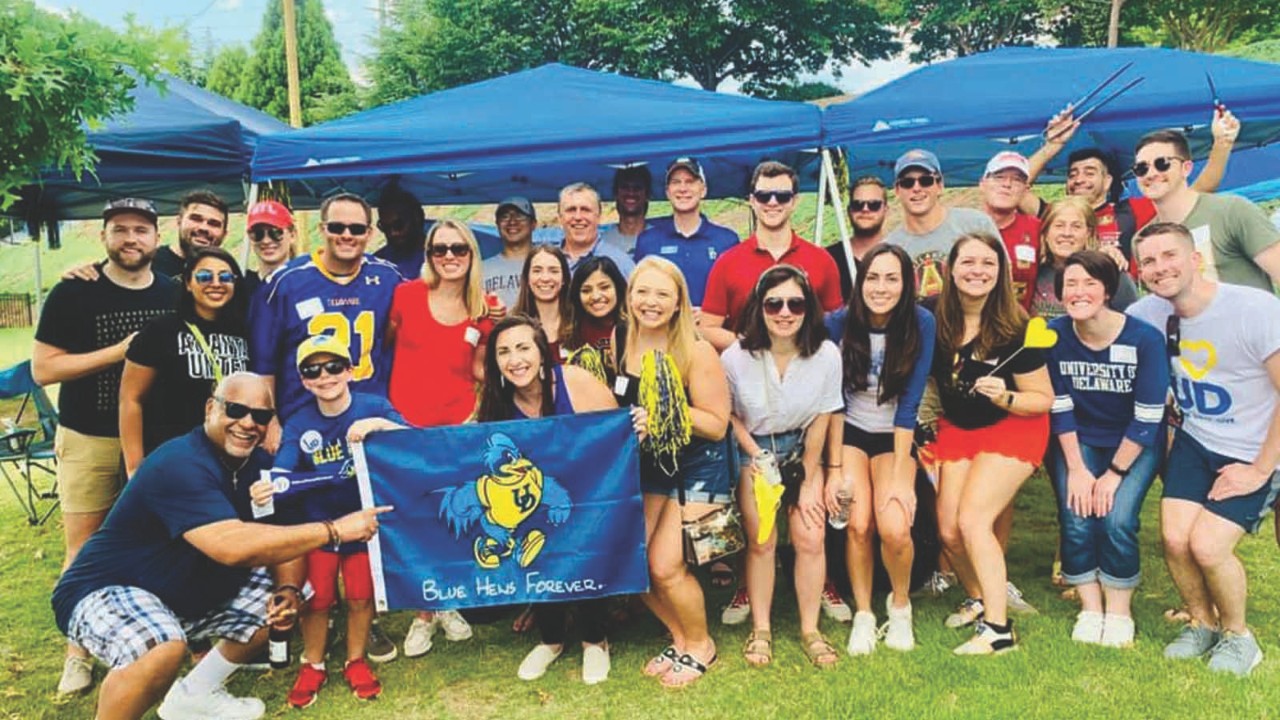 A regional alumni club poses for a group shot at an outdoor event.