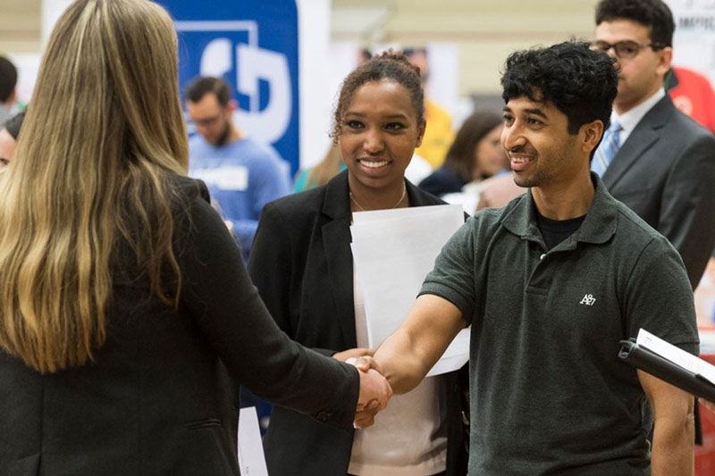 Students and faculty shaking hands.