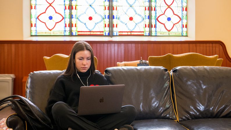 A student works on her computer at UD. 