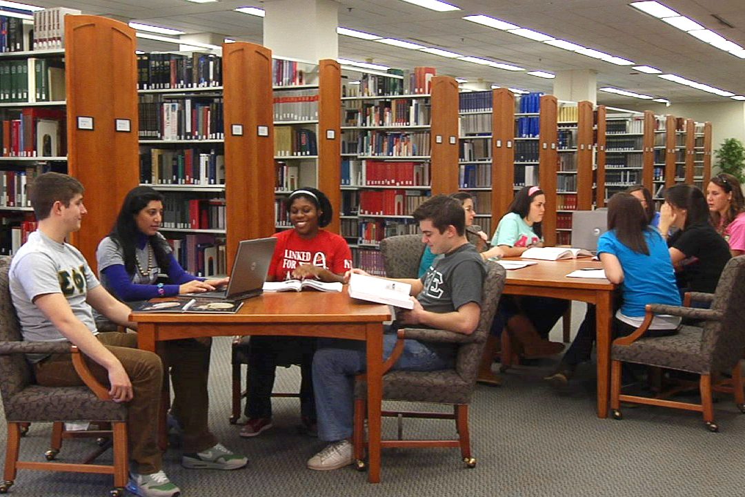 Students sit at tables in groups in Morris Library on the University of Delaware campus.