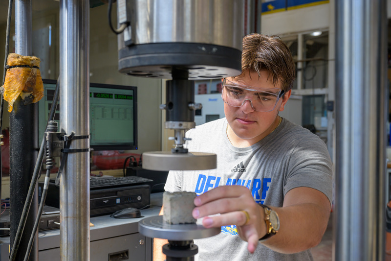 Four UD researchers work together on a one-man vehicle. 