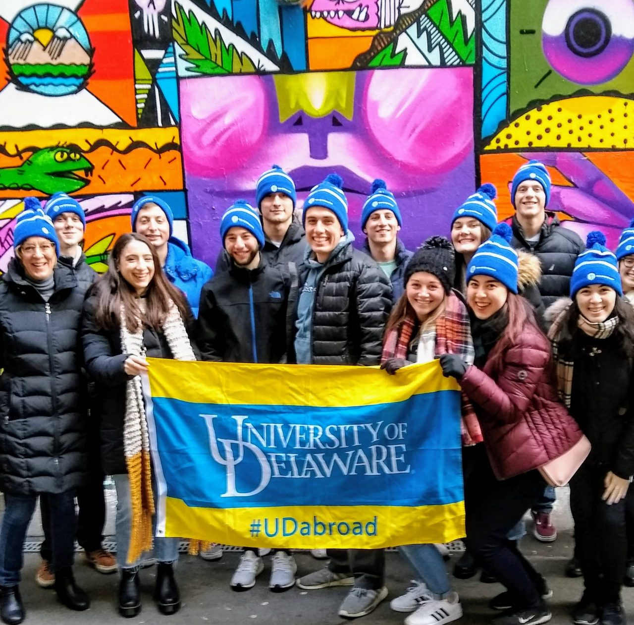 Students pose with a UD flag while abroad. 