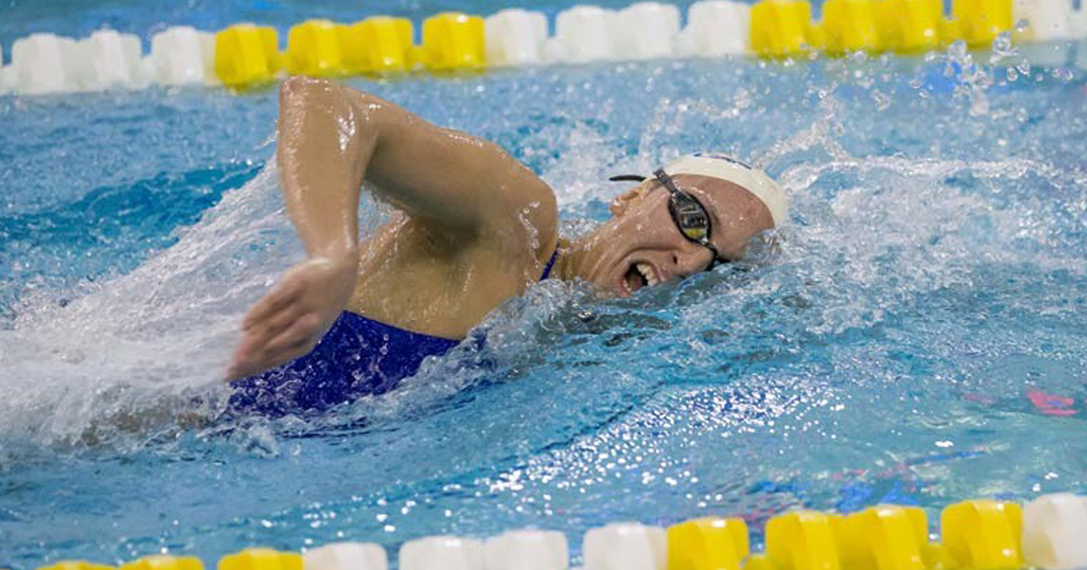 UD athlete taking a breath while swimming in a pool.