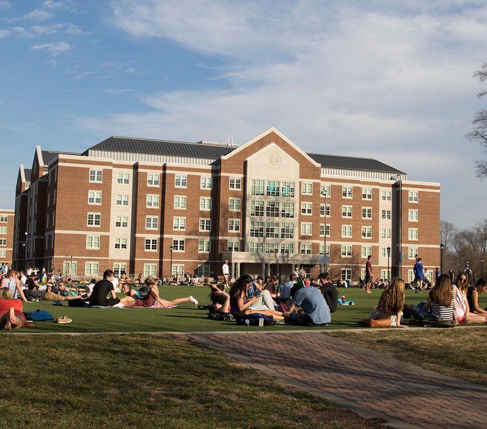 The Harrington Turf is packed with students, with Louis Redding Hall in the background.