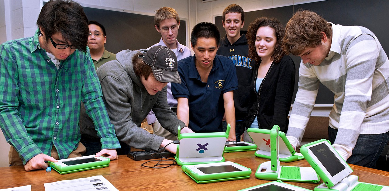 Students in a learning game development class collaborate on laptops.