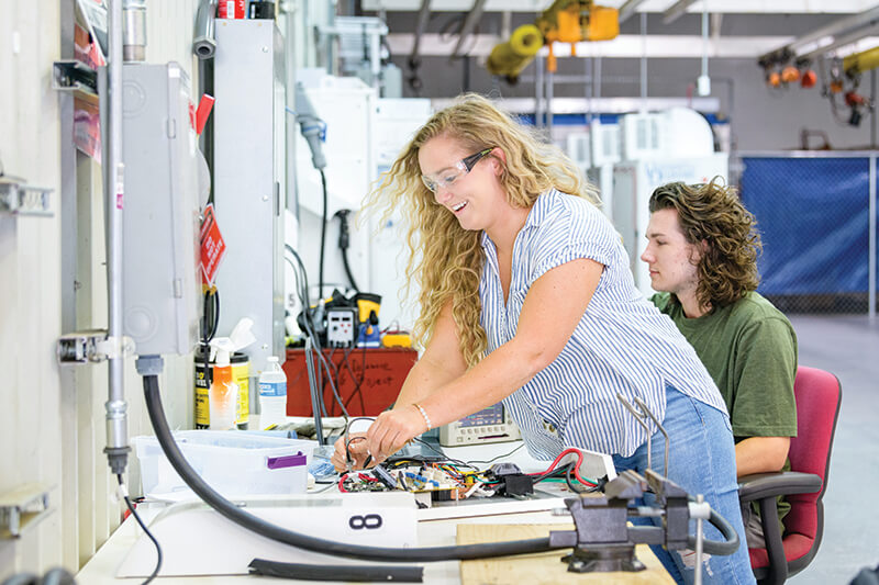 Students work on electrical systems for a vehicle to grid research project.