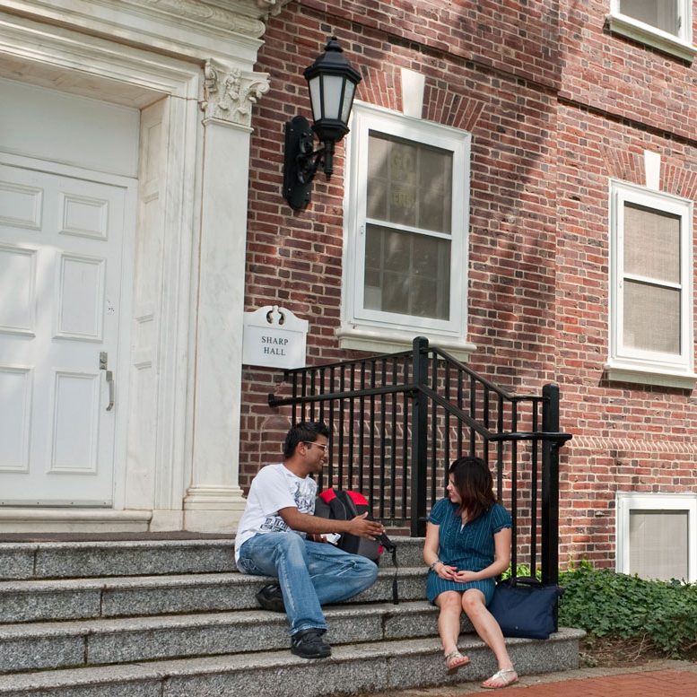 two students sitting outside Sharp Residence Hall