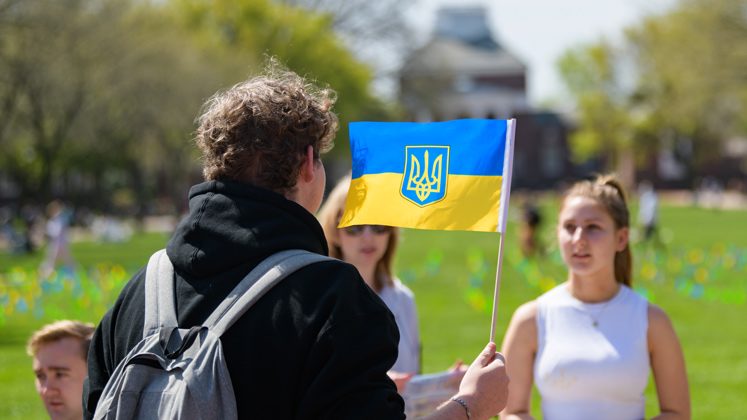 Brendan Czuczuk waves the Ukrainian flag at the Stand with Ukraine fundraiser held on Friday, April 22
