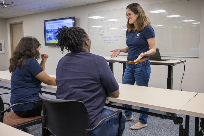 Leah Palm-Forster speaks with students and staff in the Center for Experimental and Applied Economics