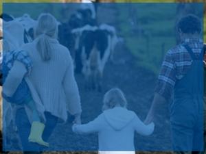 A farm family walking outside hand in hand.