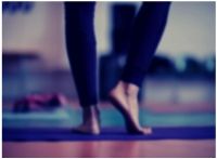 Background photo showing a person standing on a yoga mat practicing mindfulness.