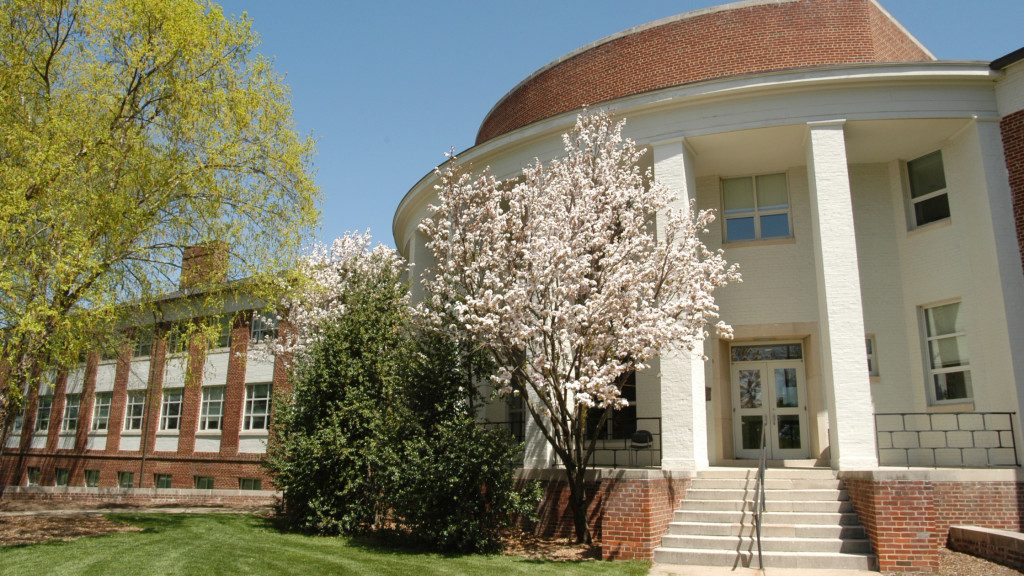 A photo of the fron of Townsend Hall with blooming trees in front.