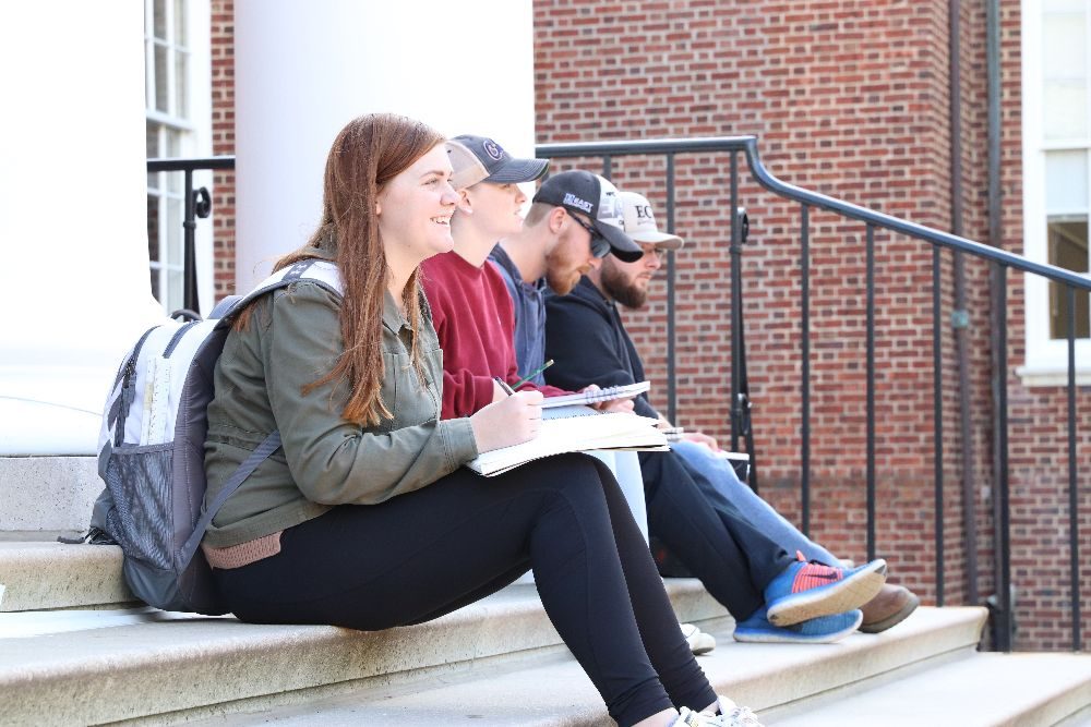 A photo of students sketching on university steps