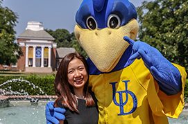 students posing with school mascot