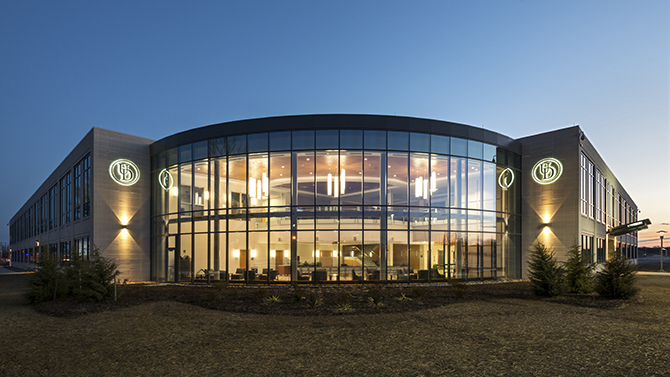 Front of Health Sciences Complex at dusk with lights glowing in North Atrium