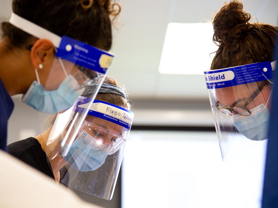 Students working in a lab wearing masks and face shields