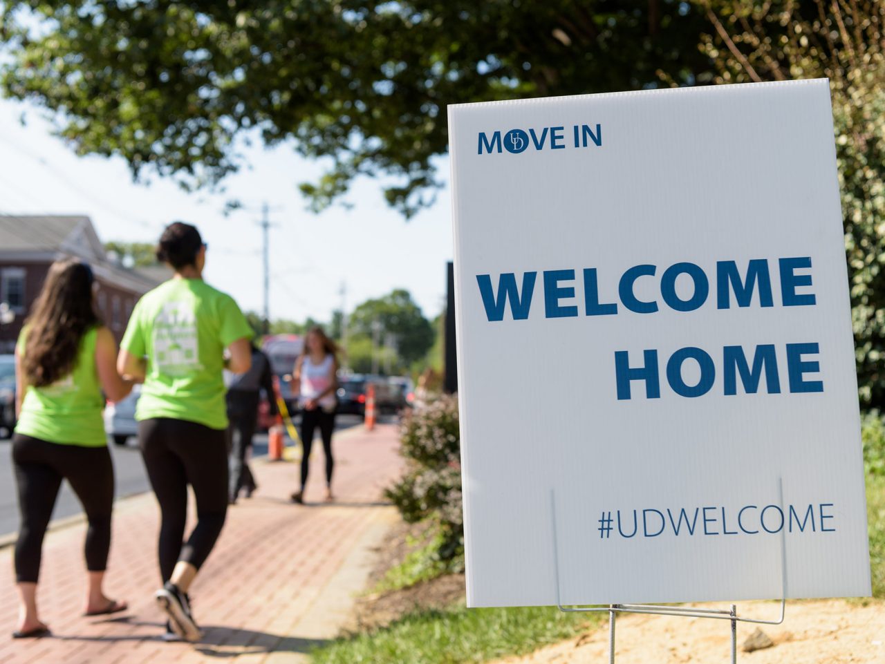 Traffic, incoming students and Blue Hen Helper volunteers outside of Smyth Residence Hall during move in.