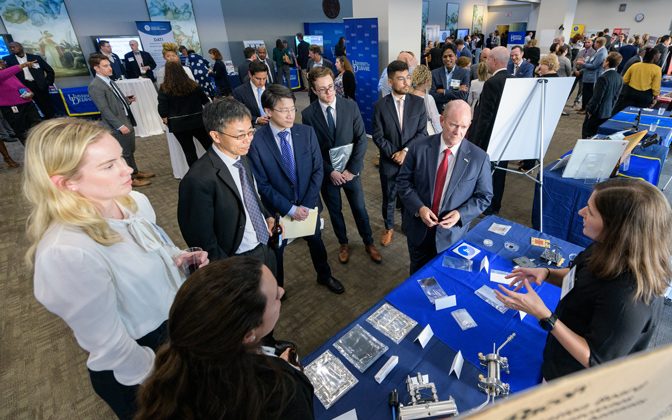 Delaware U.S. Senator Chris Coons listens as a UD researcher discusses hydrogen fuel research