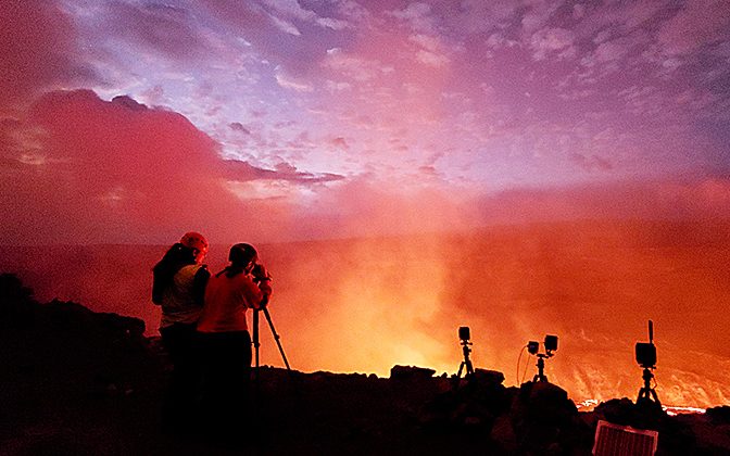 Abigail Nalesnik, doctoral student in geology at the University of Delaware, looks through a rangefinder at the eruption in Kīlauea‘s Halema‘uma‘u crater the evening of September 30, 2021.