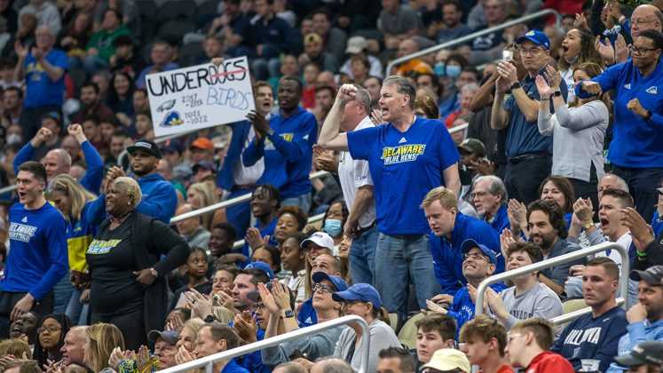 For the first time in the history of the University of Delaware, the women’s and men’s basketball teams played in the NCAA Tournament in the same year. Fans, including those shown above attending the men’s game against Villanova in Pittsburgh, were undeterred by the Blue Hens’ underdog status.