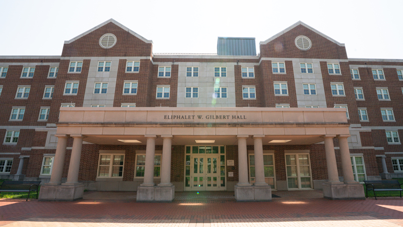 Eliphialet Gilbert Residence Hall with a brick walkway along the front of the building.