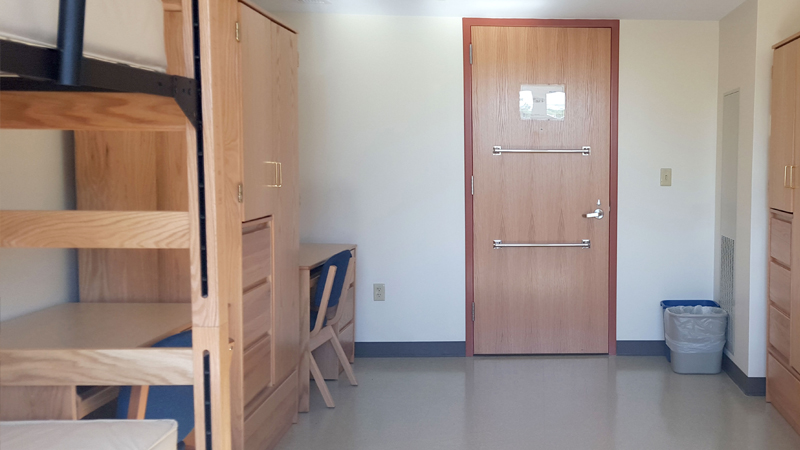 View of some furniture in a double room, including wardrobes, twin XL long beds and four-drawer dressers.