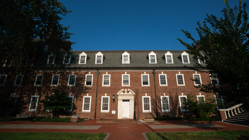 Brown Residence Hall with a brick walkway in the front, and part of a staircase to Main Street in the right corner of the picture. 