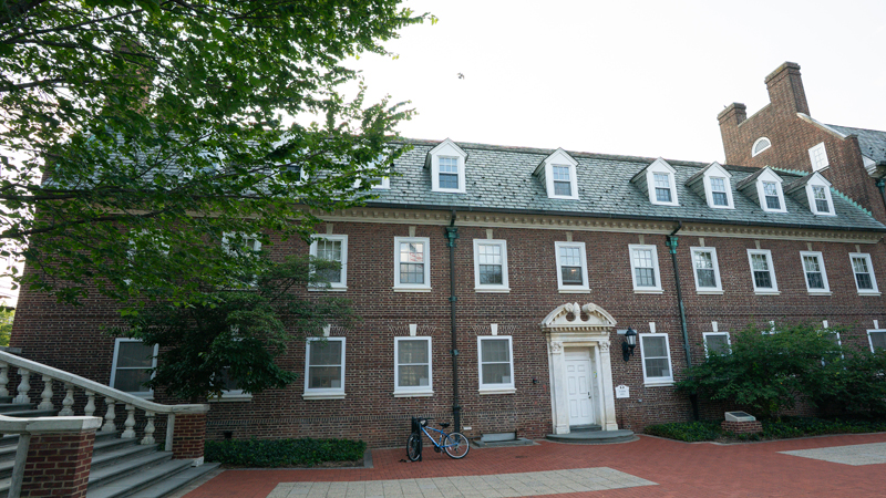 Harter Residence Hall with a brick walkway in the front, and part of a staircase to Main Street in the right corner of the picture.