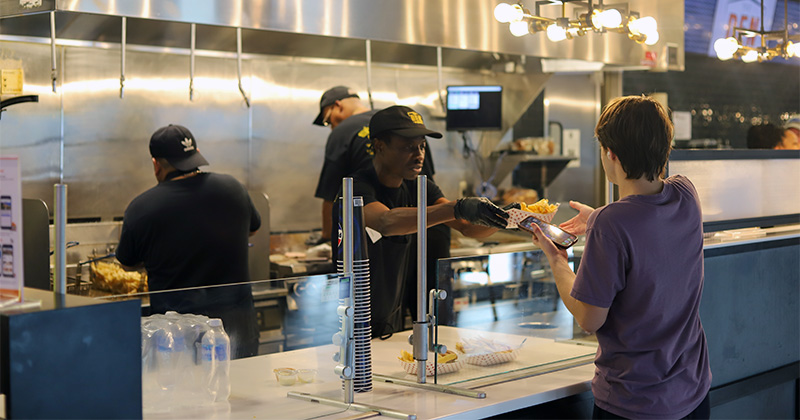 Student orders food at the Den by Denny's counter