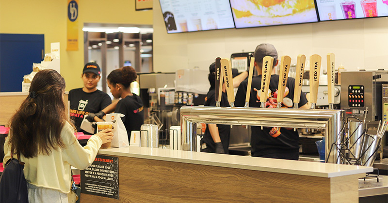 Student picks up their order at Dunkin'