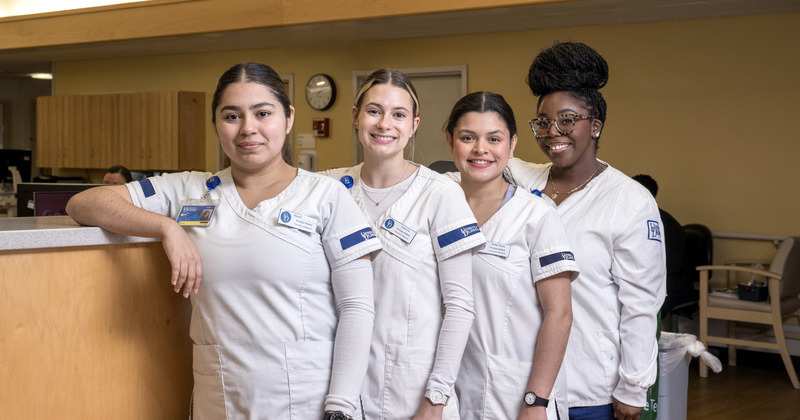 four nursing students standing in a hospital lobby