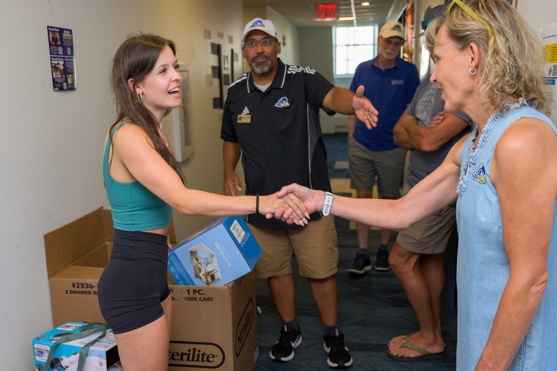 President Laura Carlson shaking hands with a first-year student during Welcome Week