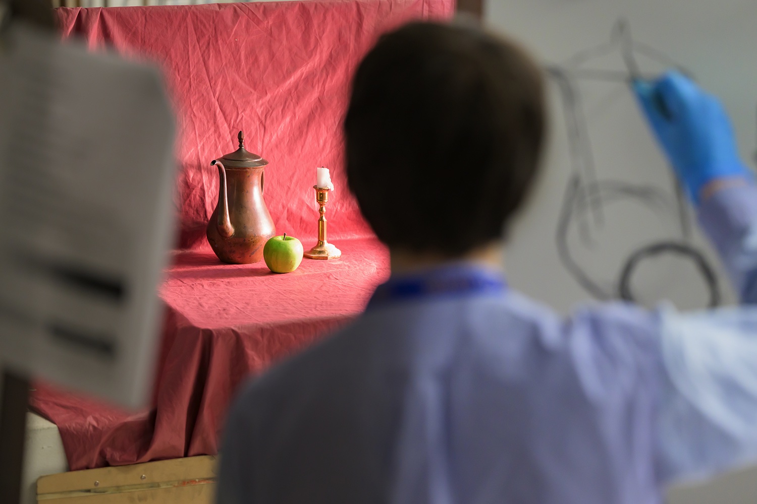 A student drawing a still life from observation.