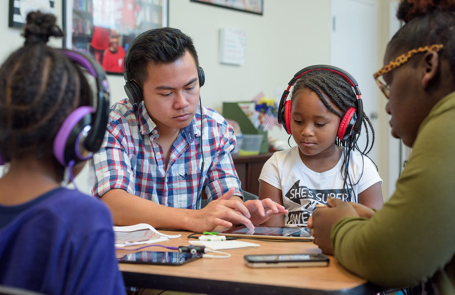 Students and children listening to an audio-based lesson in the classroom.